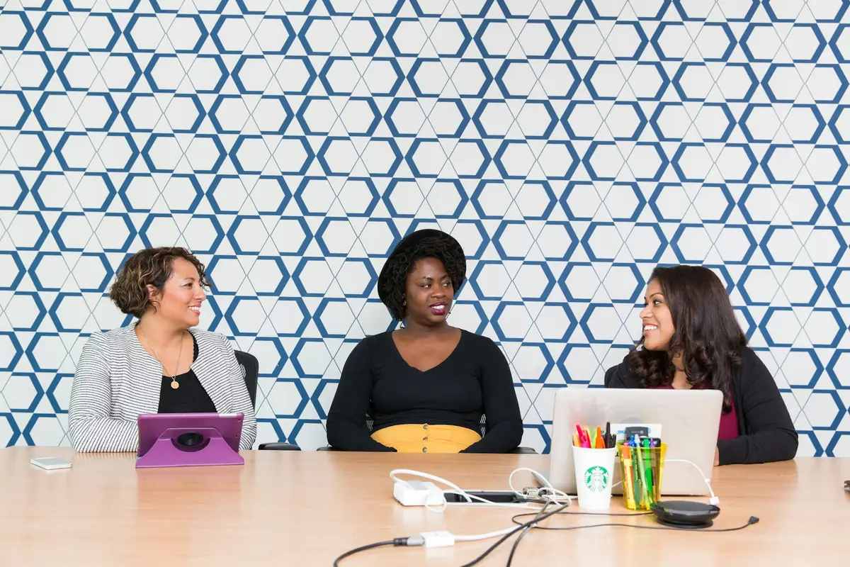 Three colleagues working together around a conference table