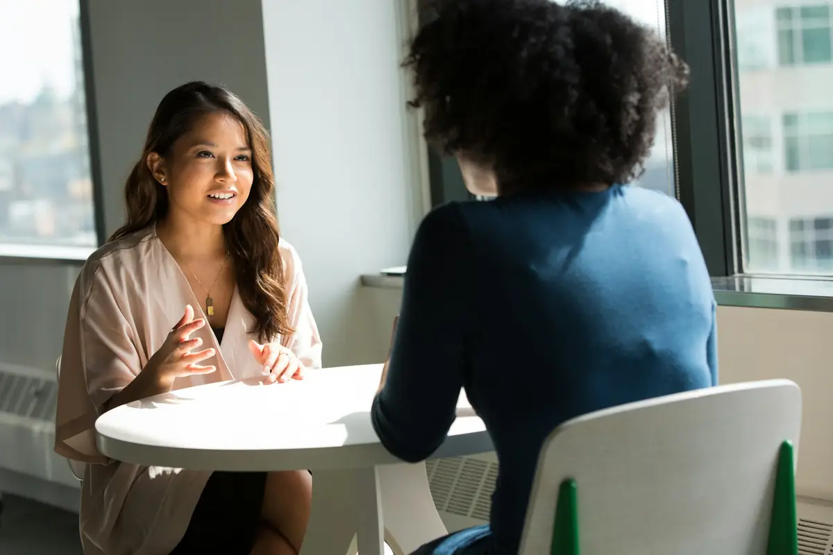 An interviewer and a candidate talking across a small table