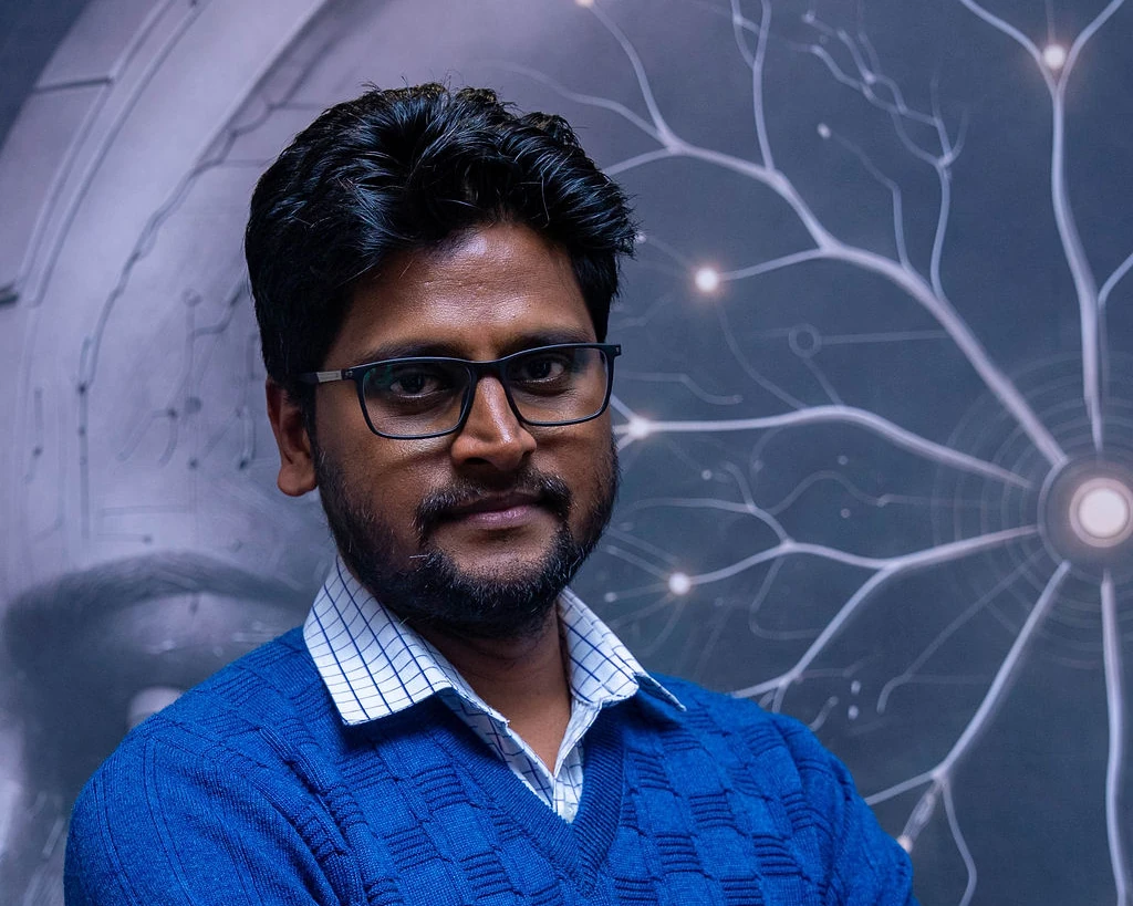 A professional in a blue jumper, arms folded